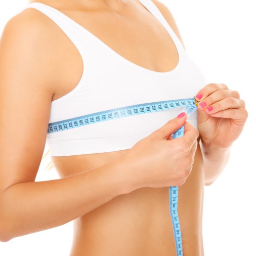 Women measures size of breast over white background