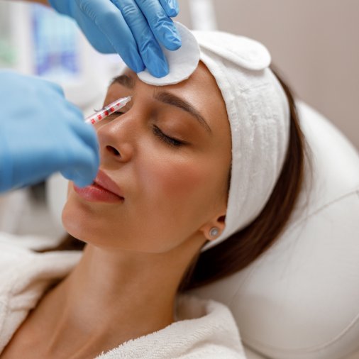 Professional cosmetologist filling forehead of woman with botox to get rid of wrinkles